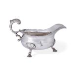 A George II silver sauce boat, London 1744, David Hennell I, raised on three shell-shouldered pad...