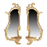 A pair of giltwood mirrors, George III style, third quarter 20th century, the carved scrolling fr...