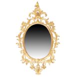 A giltwood mirror, George III style, second quarter 20th century, the moulded oval frame with pie...