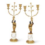 A pair of gilt and patinated bronze twin-light figural candelabra, of Regency style, 20th century...