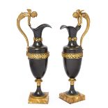 A pair of French gilt and patinated bronze ewers, late 19th century, each with winged cherub hand...