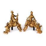 A pair of French gilt-bronze chenets, late 19th century, each with seated figure wearing a feathe...