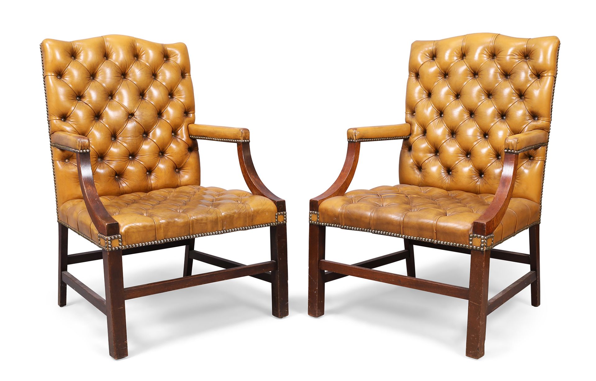 A pair of English mahogany Gainsborough armchairs, in the George III style, 20th century, with ta...