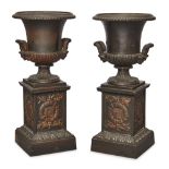 A pair of French cast-iron urns, by Mignon, late 19th century, each with twin mask handles, the s...