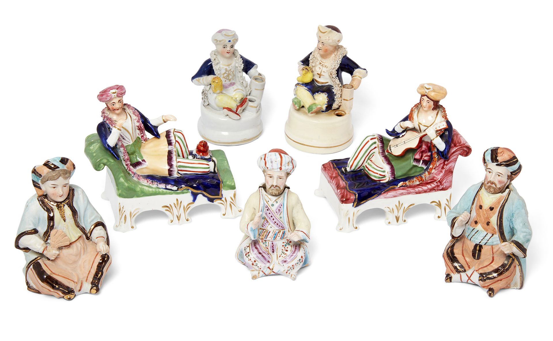 A group of seven Staffordshire figures, late 19th century, comprising: two pen holders modelled a...