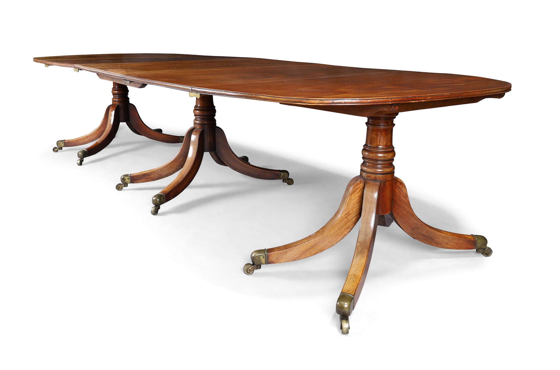 A George III mahogany dining table, last quarter 18th century, the three pedestals with turned co...