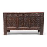 An English oak coffer, 17th century, the hinged paneled top carved with initials E.S, above highl...