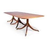 A mahogany dining table, in George III style, 20th century, the cross banded top raised three ped...