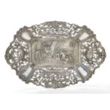 A pierced German dish, stamped 800, the flat base repousse decorated with village bowling scene, ...
