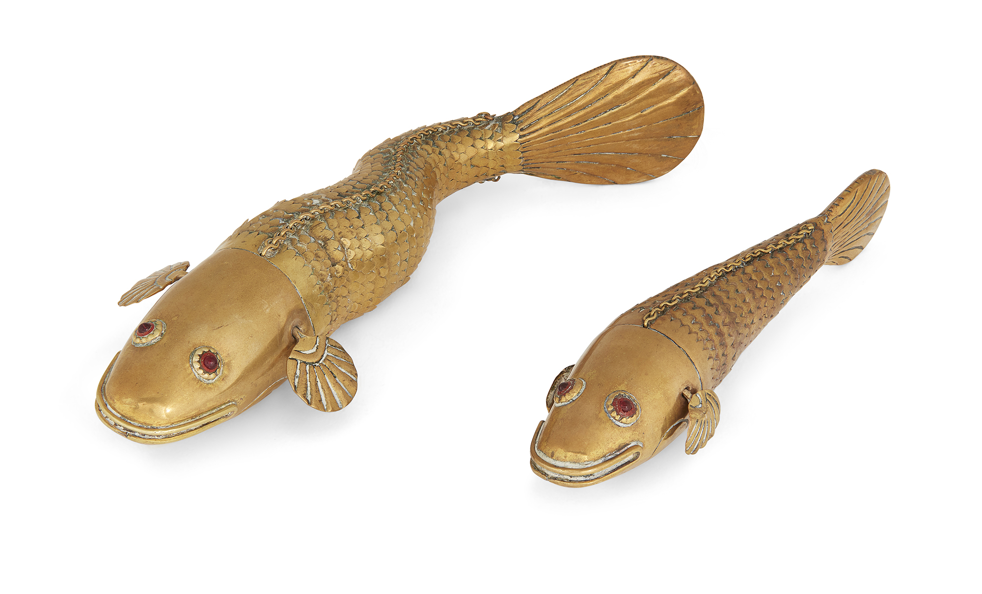 Two brass articulated Medina style fish, India, late 19th - early 20th century, both with red pas...