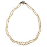 A two row natural pearl necklace, two rows of graduated natural pearls, strung knotted, to a gold...