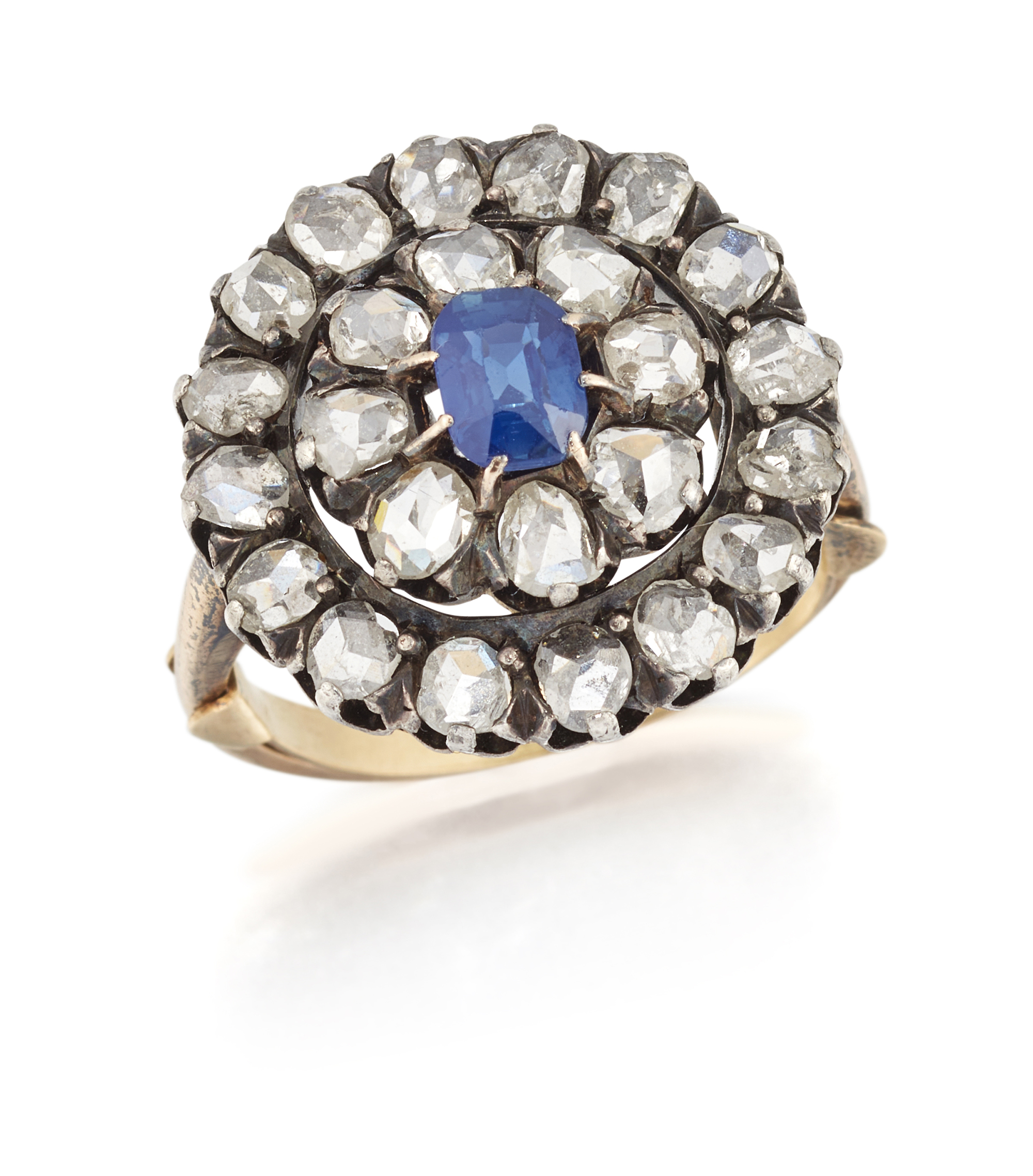 A late 19th century sapphire and diamond cluster ring, the cushion cut sapphire to double row ros...