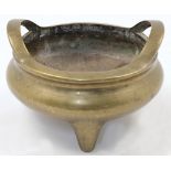A Chinese bronze censer, early 20th century, cast in circular form with twin high loop handles an...