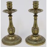 A pair of gilt bronze candlesticks, 18th century, the baluster stems with lobed terminals above d...