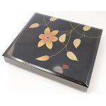 A Japanese black lacquer rectangular box and cover, 20th century, painted to the cover in gilt wi...