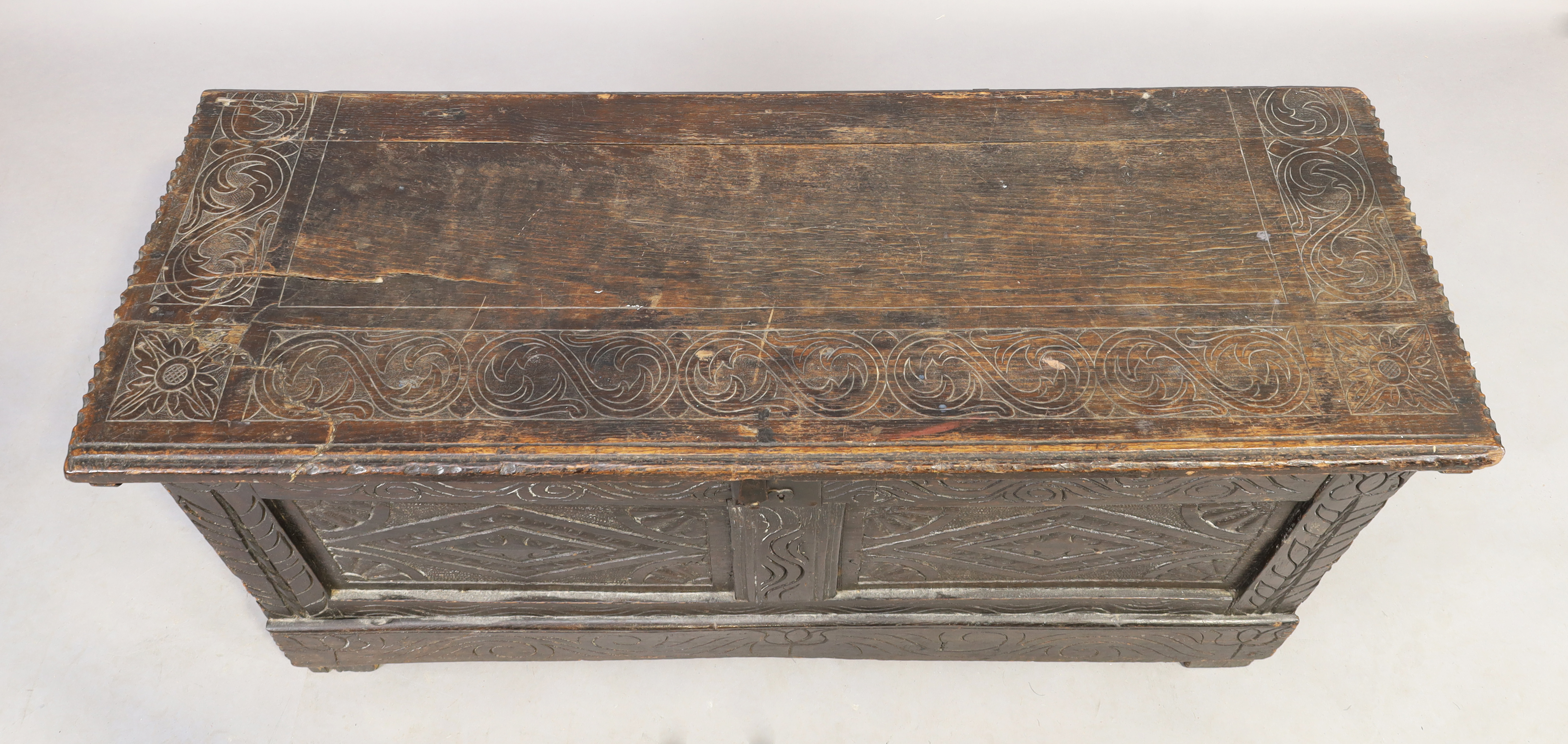 An English oak coffer, 18th century, floral carved, the hinged lid enclosing candle box and compa... - Image 4 of 4