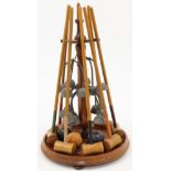 An Edwardian table top croquet set, early 20th century, comprising a turned stand fitted with eig...