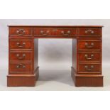 An English mahogany pedestal desk, 20th century, with tooled green leather writing surface above ...