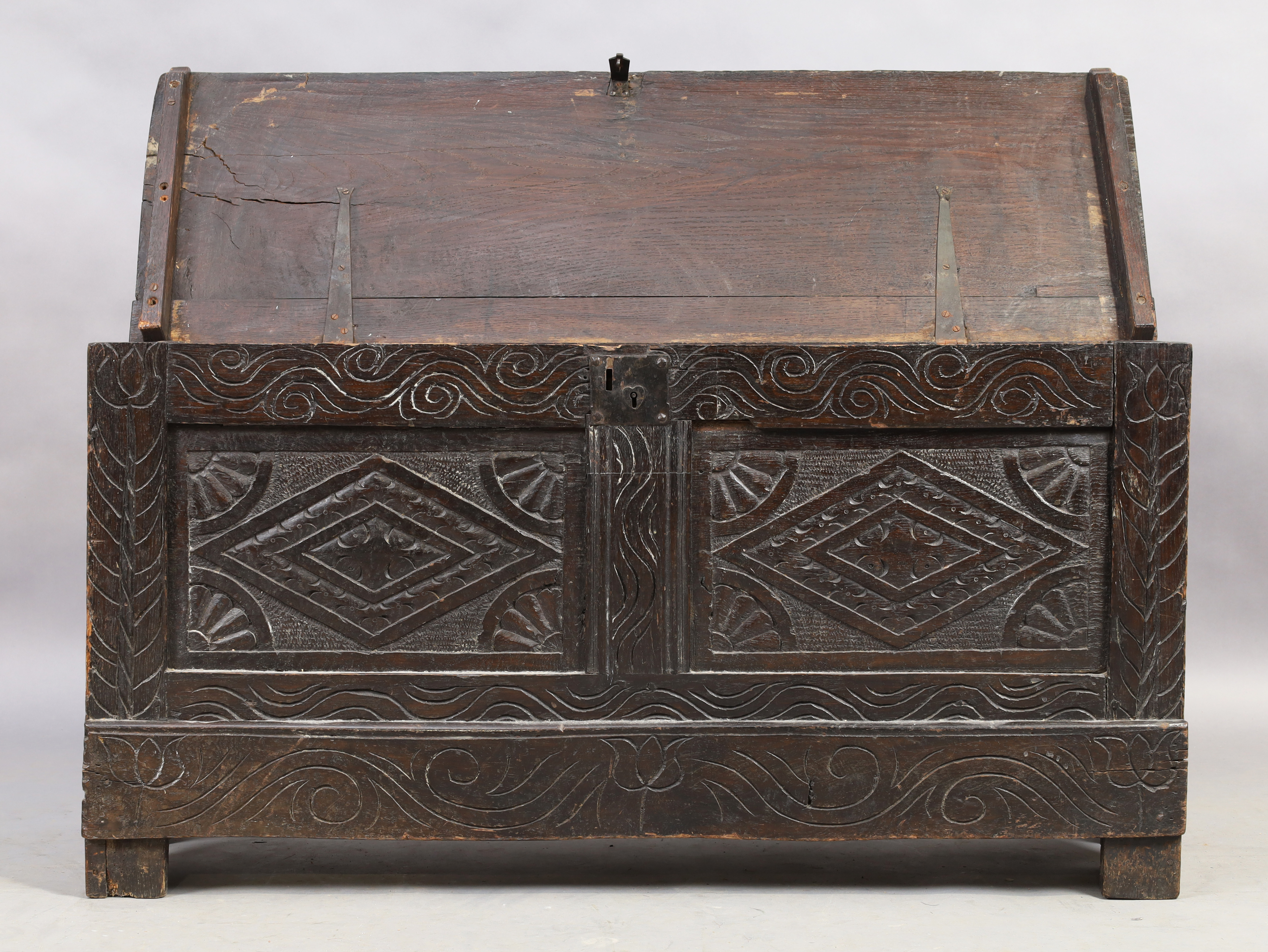 An English oak coffer, 18th century, floral carved, the hinged lid enclosing candle box and compa... - Image 2 of 4