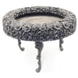 An ebony plant stand, 19th century, the border intricately carved with a flowers, leaves and smal...