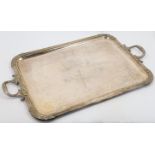 A large silver plated tray, with twin foliate handles, the centre chased with vacant cartouche an...