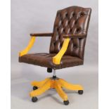 A brown leather desk chair, in the George III style, 21st century, with button back upholstery, o...