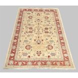 A Ziegler rug, the central field with geometric floral design, on a cream ground, contained by ge...