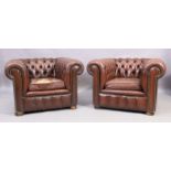 A pair of chesterfield brown leather armchairs, 20th century, with button back upholstery, raised...