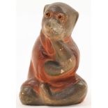 A Japanese stoneware monkey, Meiji period, he moulded animal hollowed inside, seated with legs cr...