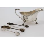 A silver sauceboat, Birmingham, 1937, Bravingtons Ltd., with scroll handle, on three shell feet, ...