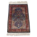 A Hereke silk rug, third quarter 20th century, the central medallion with floral motifs, on a blu...