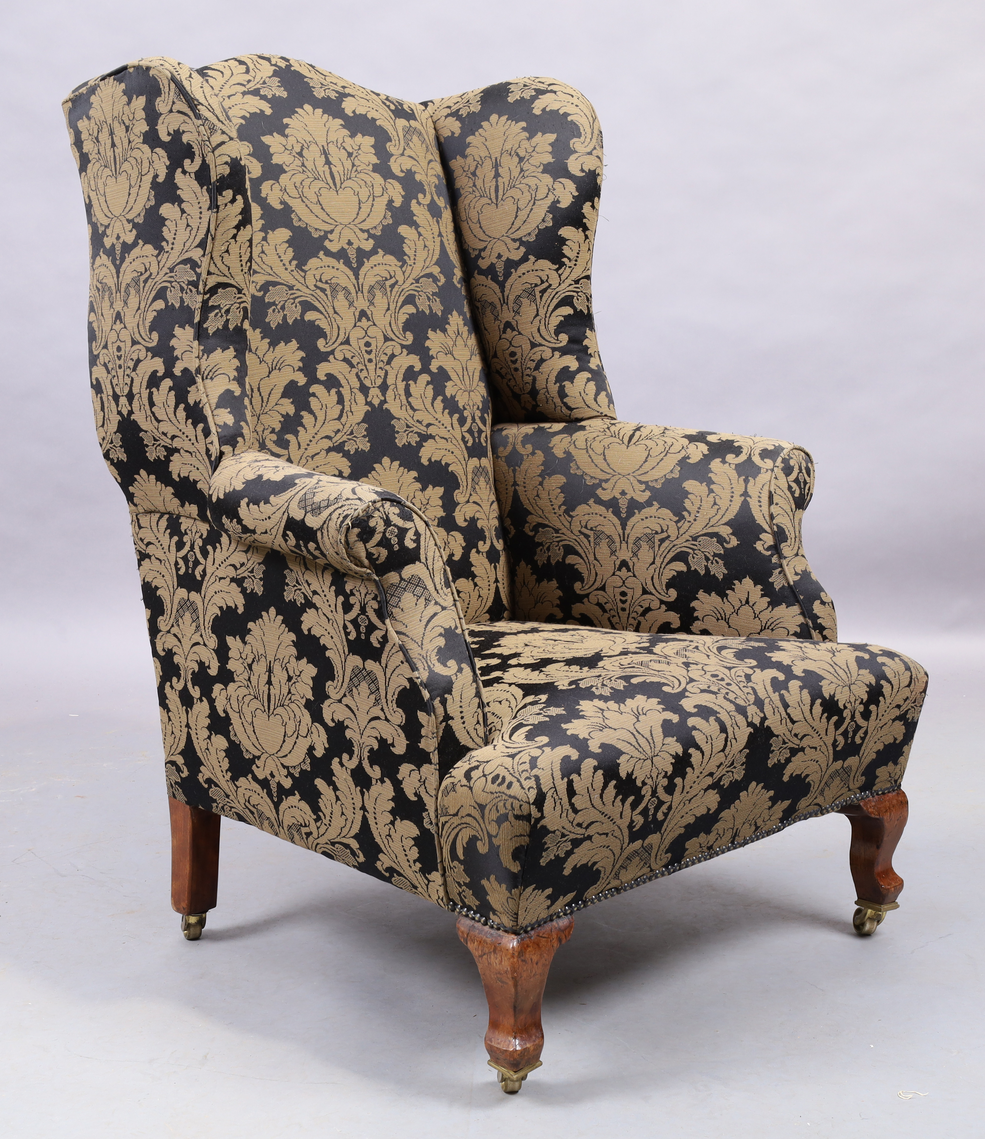 An English mahogany wingback armchair, George III style, last quarter 19th century, with black an...