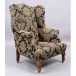 An English mahogany wingback armchair, George III style, last quarter 19th century, with black an...