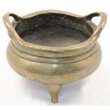 A Chinese bronze censer, 19th century, cast in circular form with twin high loop handles and thre...