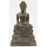 A Burmese bronze buddha, 18th century, depicted seated with serene smiling face, closed eyelids a...