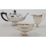 A silver three-piece tea set, Sheffield, 1923, maker HLB, comprising: a teapot with ebonised hand...