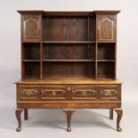 An English oak dresser, first quarter 18th century, the plate rack with two cupboards above one l...