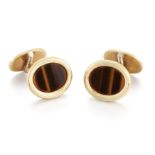 Piaget. A pair of tiger's eye cufflinks, oval bezel-set tiger's eye tablets to swivel fittings, s...