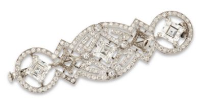 An Art Deco diamond brooch, with three claw-set carré-cut diamonds, (two diamonds lacking), to pi...