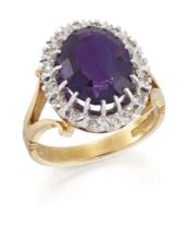 An 18ct gold amethyst and diamond cluster ring, an oval mixed cut amethyst to surround of single-...