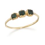 An emerald three stone ring, the rectangular cut emeralds within closed back setting, possibly Ge...