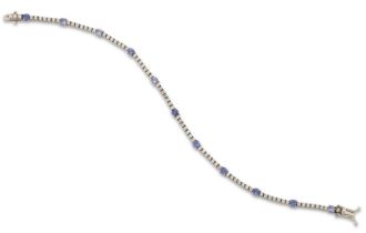 A tanzanite and diamond bracelet, composed of a series of round mixed-cut tanzanites with rows of...