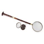A tortoiseshell and brass library magnifying glass, c.1840-50, the long tapering handle mounted w...