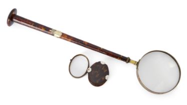 A tortoiseshell and brass library magnifying glass, c.1840-50, the long tapering handle mounted w...