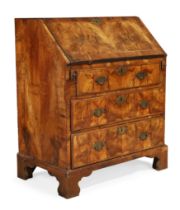 A George I feather banded walnut bureau, first quarter 18th century, the fall front with fitted i...