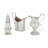 Two George III silver cream jugs and a George III silver caster, the baluster shaped jug designed...