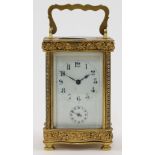 A French gilt-brass and glass panelled carriage clock, 20th century, the serpentine front and bac...