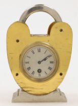 A brass cased desk clock of padlock form, early 20th century, with compass top, the circular silv...