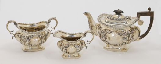 An Edwardian silver three-piece tea set, comprising: a teapot, a cream jug and a twin handled sug...