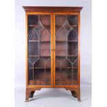 An English mahogany bookcase, 19th century, the stepped cornice above two astragal glazed doors, ...